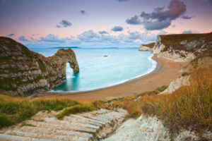 Stone steps leading down to a beach on a coast.
