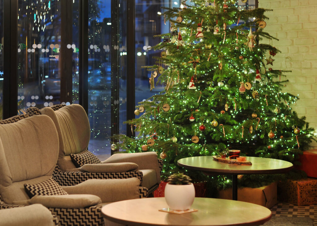 Tables and chair lined up in front of a large Christmas tree.