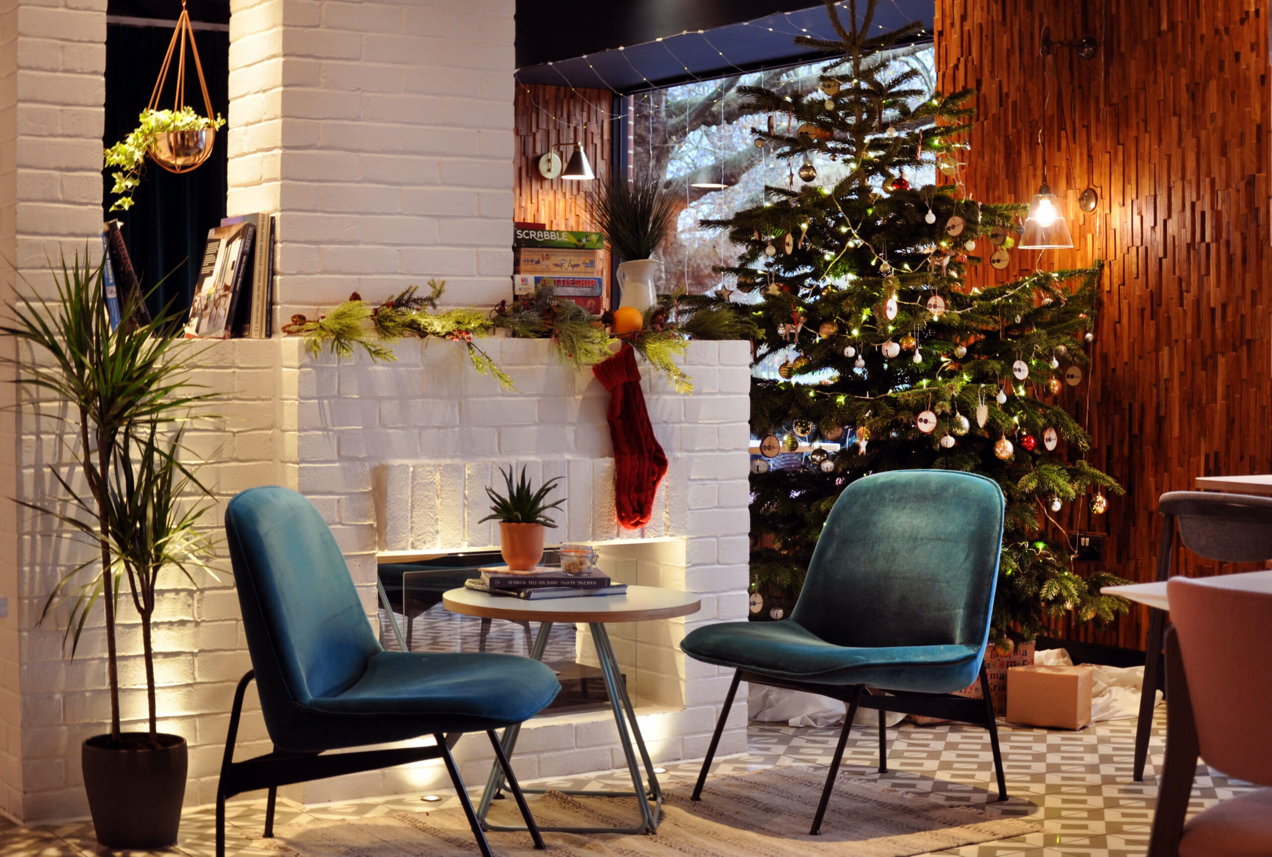 Hotel lobby with tables and chairs decorated with a Christmas tree and stockings.