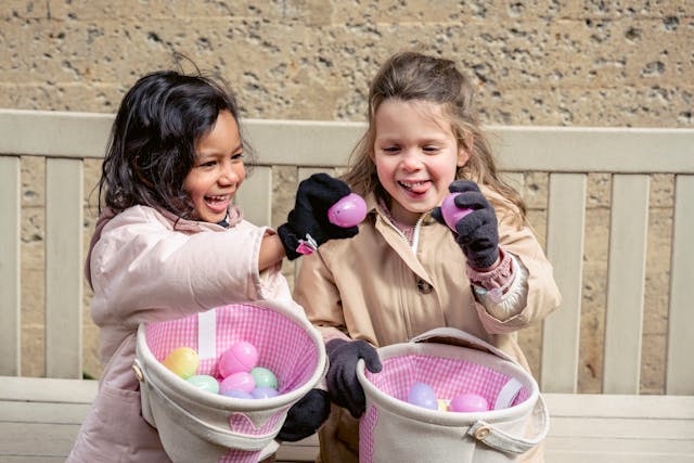 two girls happily checking their hunted easter eggs in belfast